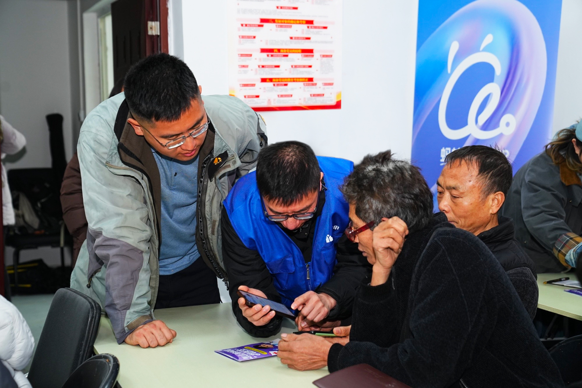 在蓝马甲志愿者的帮助下，村医们认真学习如何使用蚂蚁阿福app	。